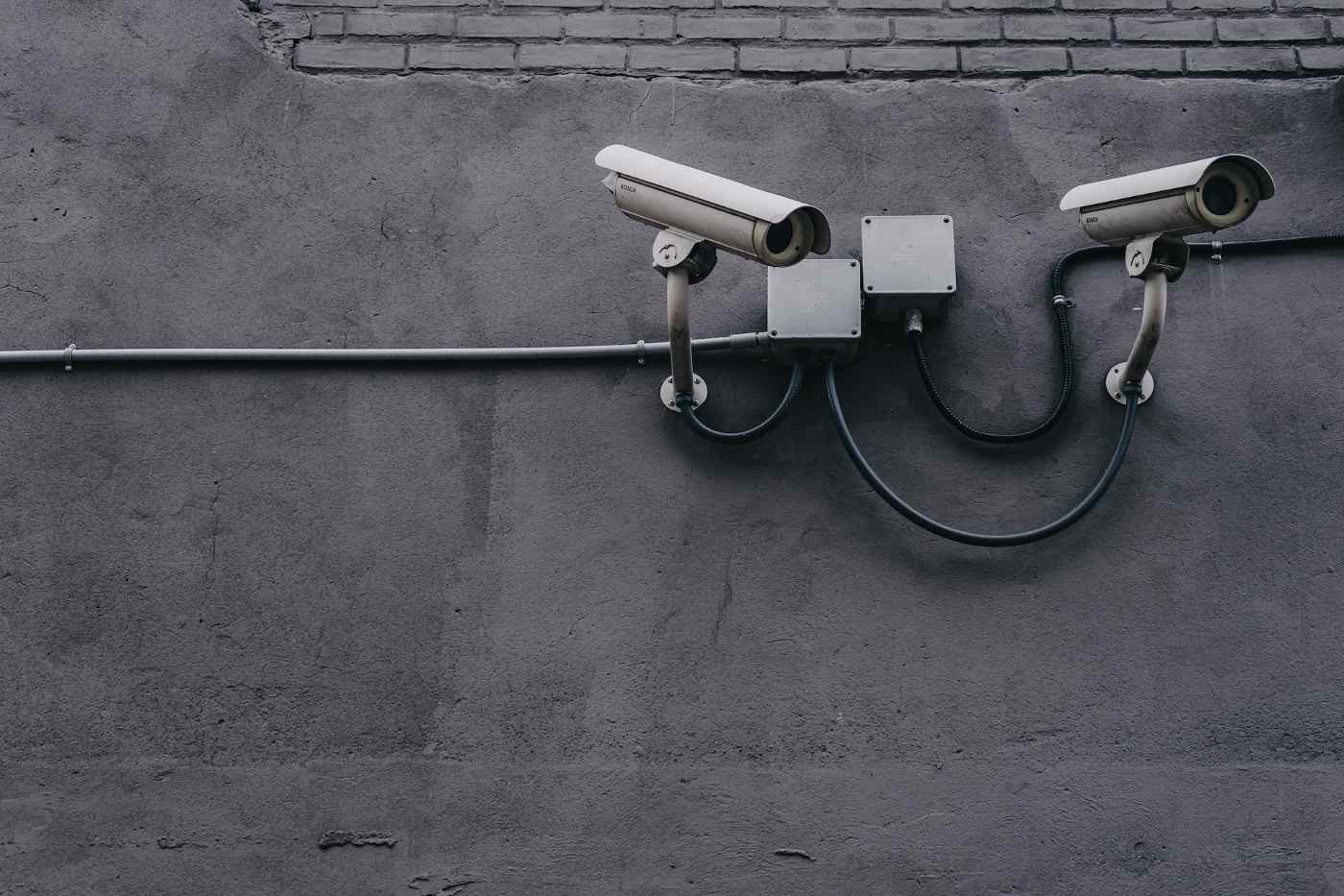 two security cameras on a grey wall - mdr for construction companies