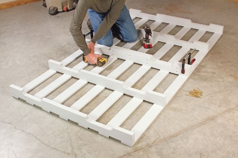 DIY Platform Bed: Create Your Own Queen-Sized Bed from Reclaimed Pallets 5 Builder fastening two pallets together - DIY platform bed