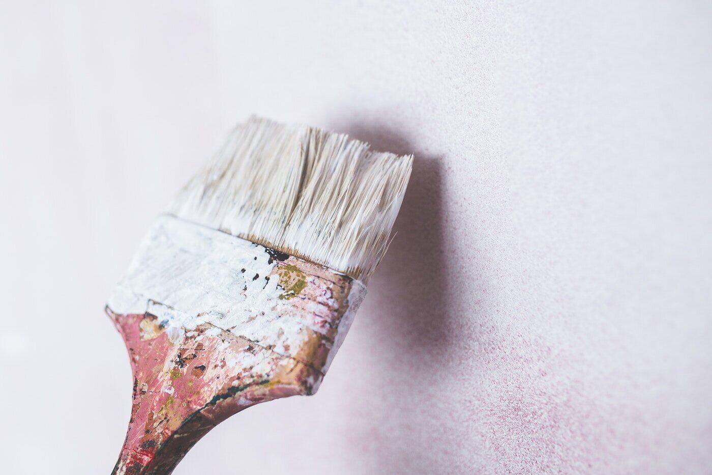 paintbrush painting white wall - hacks for eco-friendly painting