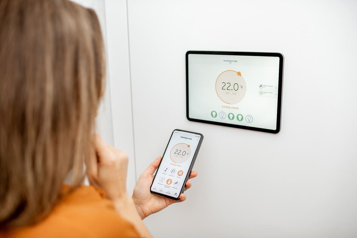 smart thermostat being programmed for house