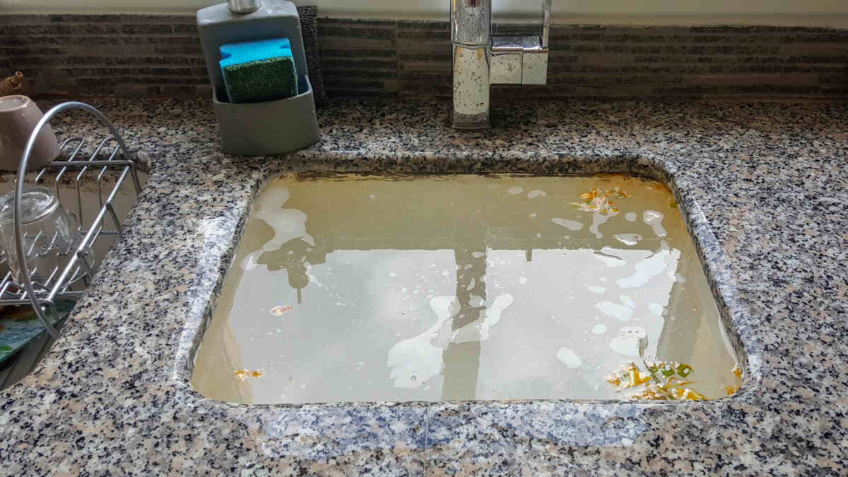 How to Clear a Blocked Drain Naturally: 9 DIY Methods That Work 1 kitchen sink drain clogged - water filled to top